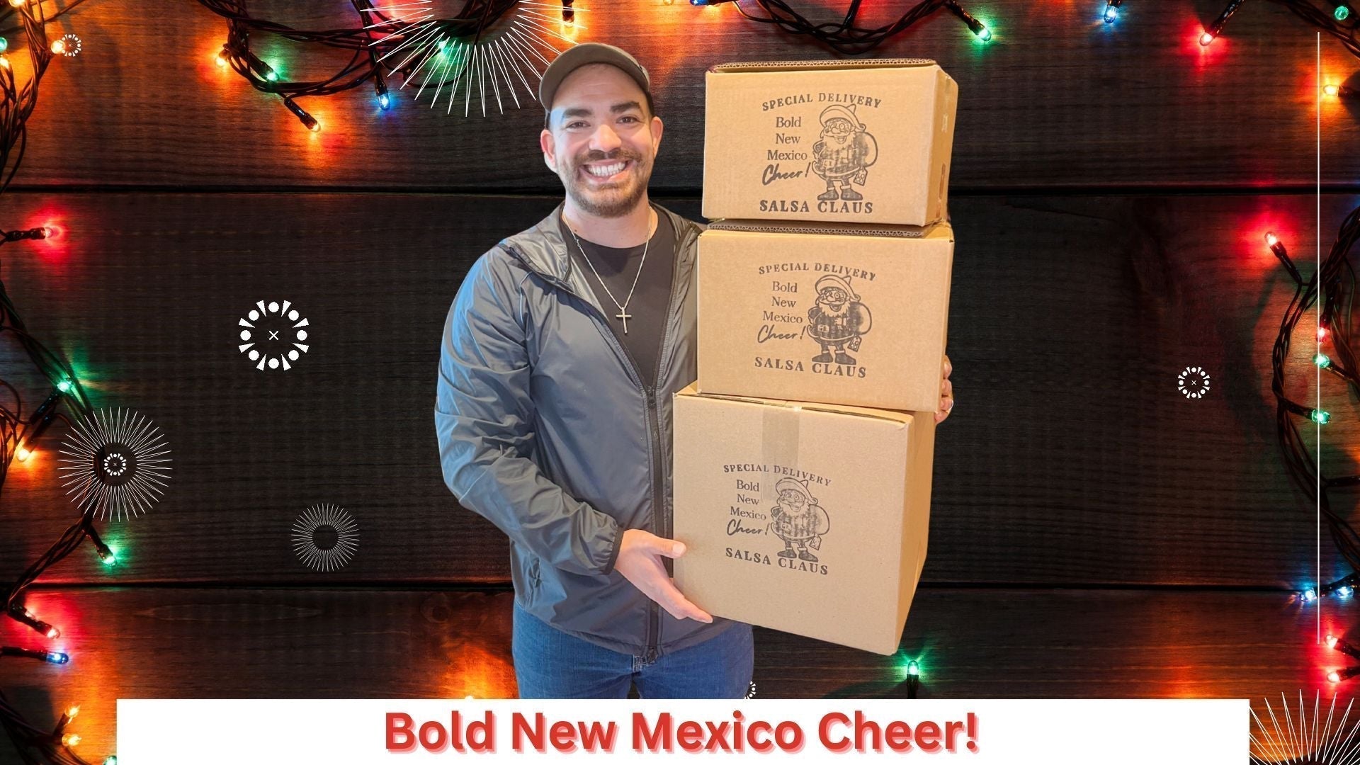 Man holding Gilly Loco gift boxes surrounded by colorful holiday lights featuring seed oil free tortilla chips and authentic Hatch chile salsas from New Mexico.