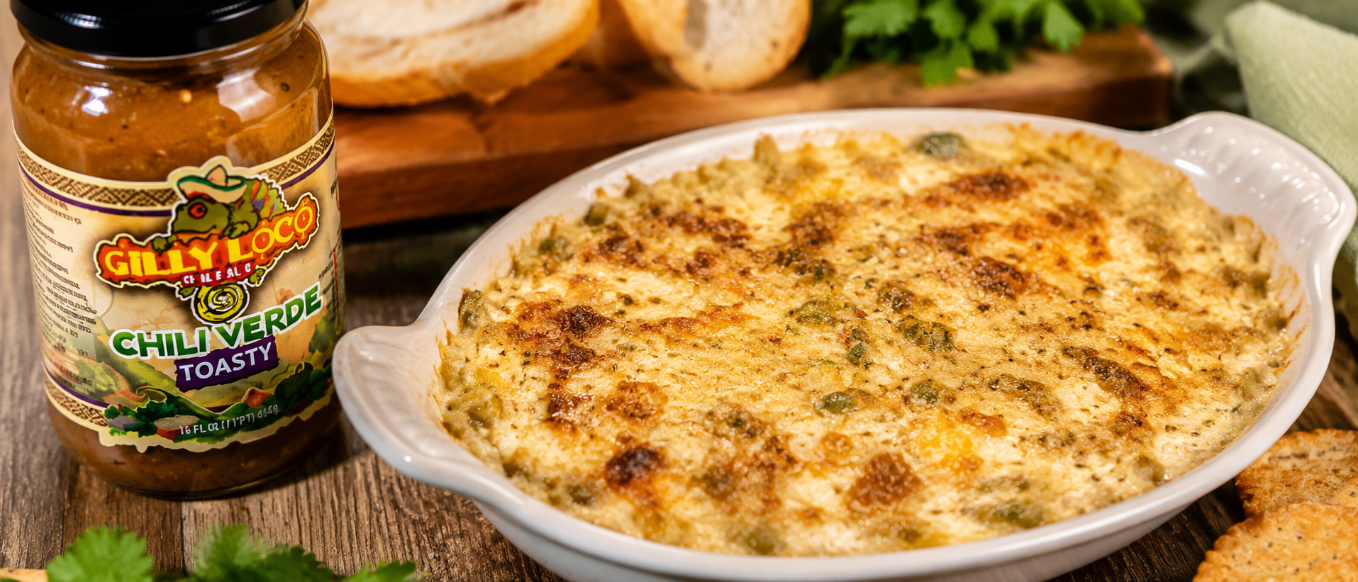 Gilly Loco hot crab artichoke dip baked until golden and bubbly with Hatch green chile flavor served with toasted bread in a rustic Southwest kitchen