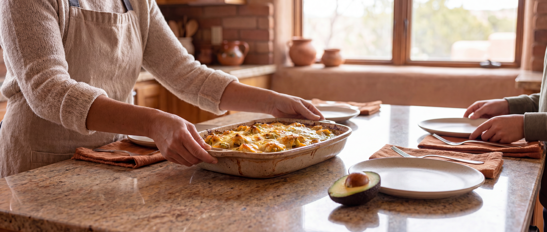 Freshly baked Hatch green chile chicken casserole being placed on a kitchen island before a family dinner in a warm New Mexico home.