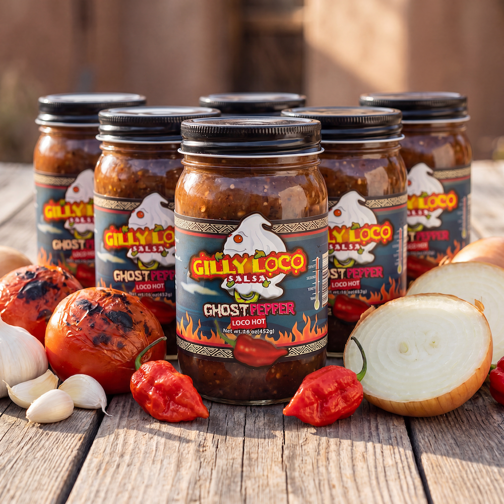 Six jars of Gilly Loco Ghost Pepper Salsa surrounded by ghost peppers, fire-roasted tomatoes, garlic, and onions on a rustic wooden table.