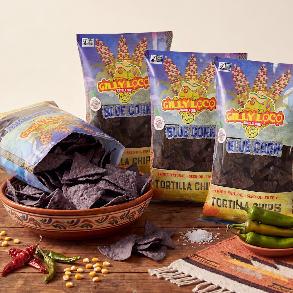 Gilly Loco Blue Corn Seed Oil Free Tortilla Chips 4-pack with crispy blue corn chips, Southwest spices, and authentic New Mexico snack styling on a rustic wooden table.