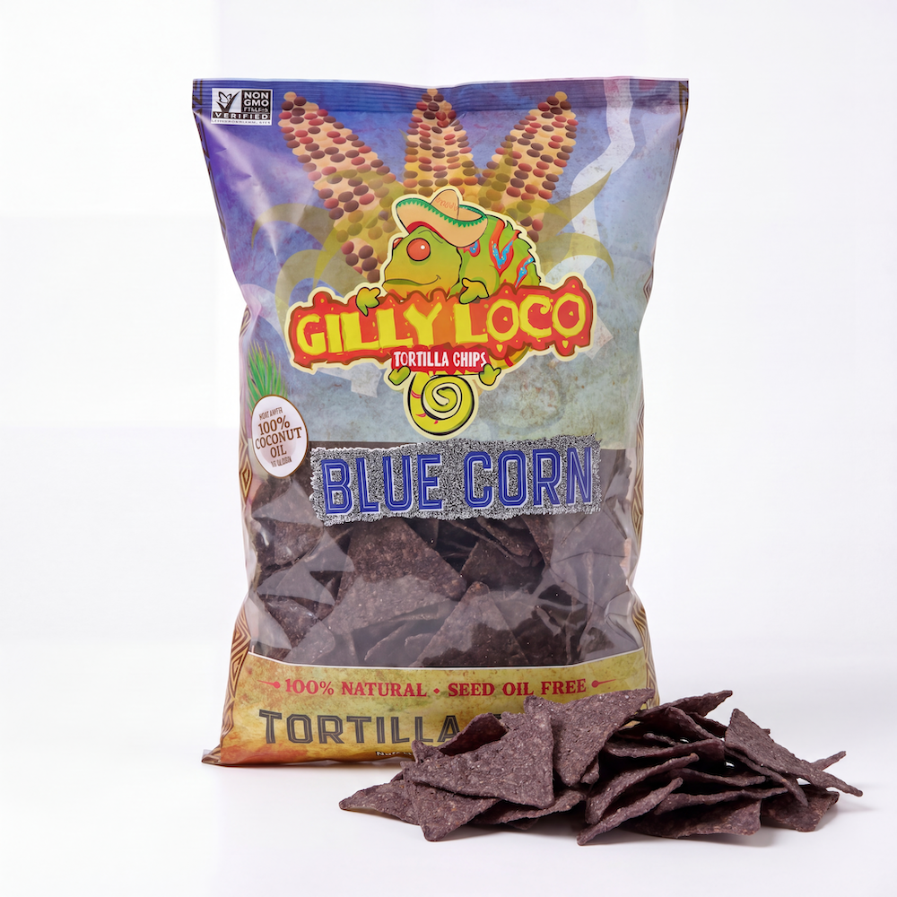 Bag of Gilly Loco Blue Corn Seed Oil Free Tortilla Chips cooked in 100% coconut oil with crispy blue corn tortilla chips on a clean white background.